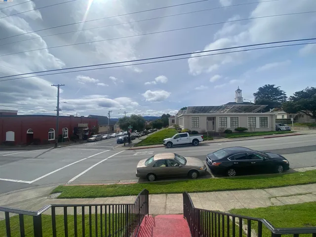a view of a city street with parked cars