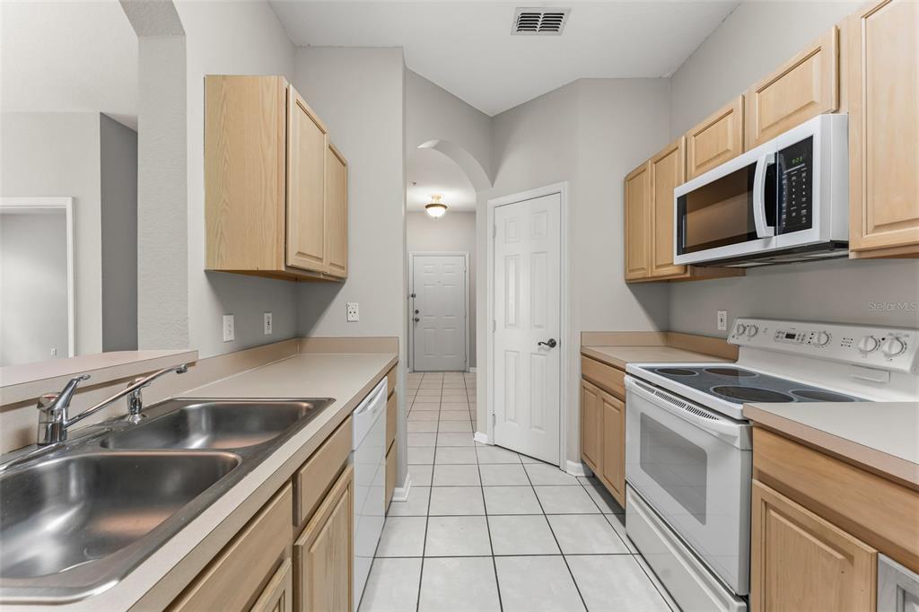 1224 South Hiawassee Road, Unit 636 Orlando, FL 32835 - Photo 13 of 43 a kitchen with stainless steel appliances granite countertop a sink stove and microwave