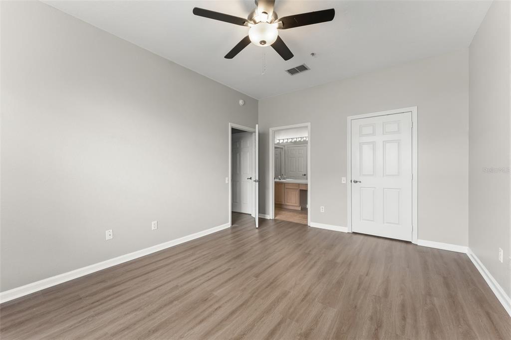 1224 South Hiawassee Road, Unit 636 Orlando, FL 32835 - Photo 29 of 43 an empty room with wooden floor ceiling fan and windows
