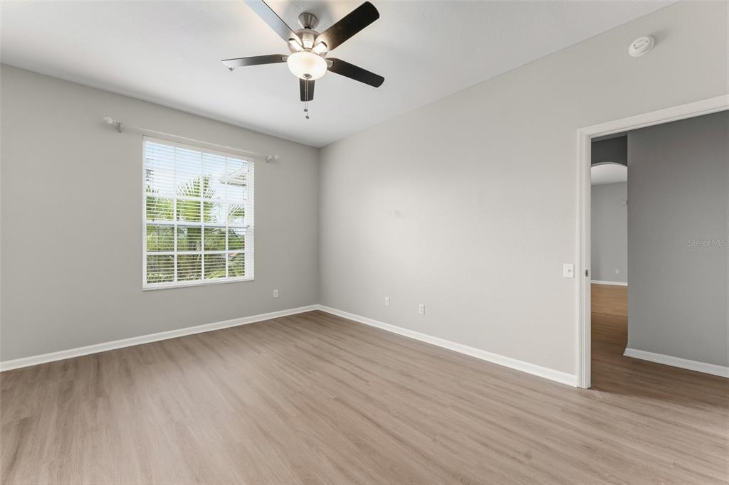1224 South Hiawassee Road, Unit 636 Orlando, FL 32835 - Photo 30 of 43 an empty room with wooden floor a ceiling fan and windows