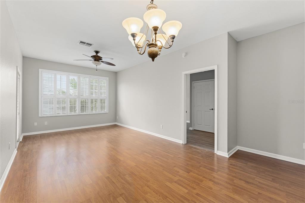 1224 South Hiawassee Road, Unit 636 Orlando, FL 32835 - Photo 7 of 43 an empty room with wooden floor chandelier and windows