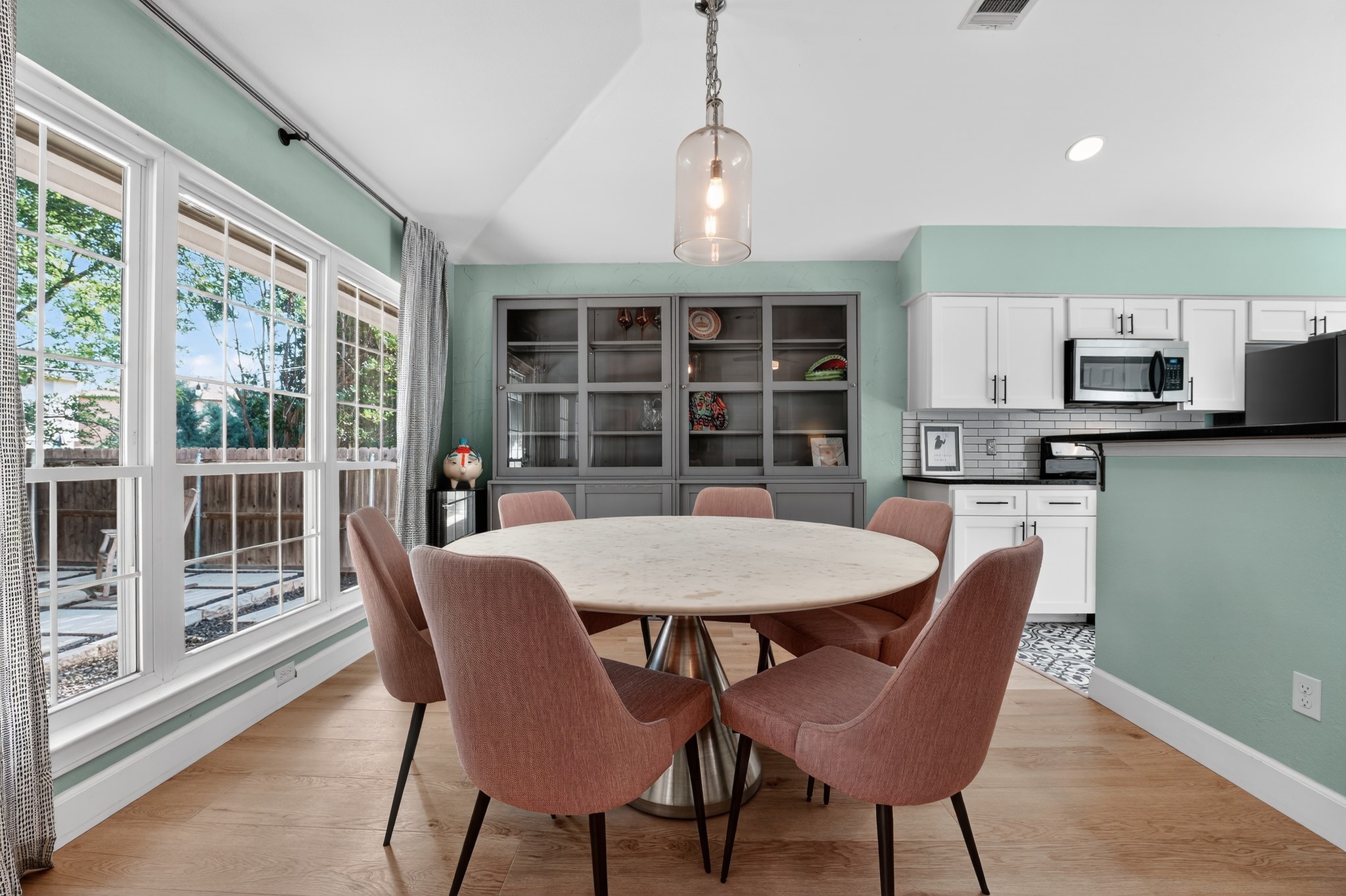 1811 Old Mill Road Cedar Park, TX 78613 - Photo 10 of 39 Natural light floods this dining area, featuring a generous window overlooking the backyard and an elegant ceiling light fixture.