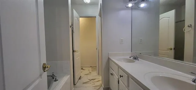 a bathroom with a sink and mirror with toilet