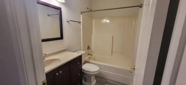 a bathroom with a granite countertop toilet sink and shower