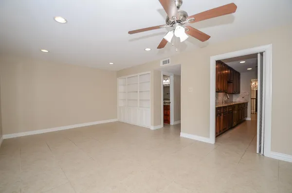 an empty room with wooden floor and ceiling fan