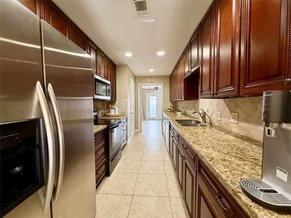 a bathroom with a granite countertop sink a mirror and a toilet