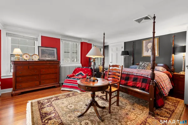 a bedroom with a bed and wooden floor