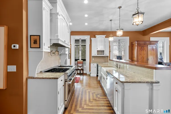 a kitchen with stainless steel appliances granite countertop a sink stove and refrigerator