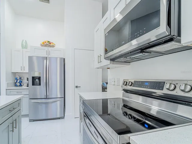 a kitchen with stainless steel appliances granite countertop a refrigerator and a stove