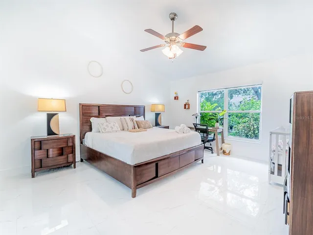 a bed sitting in a spacious bedroom next to a window