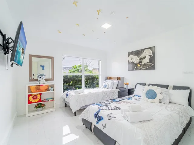 a bedroom with two beds and a painting on the wall