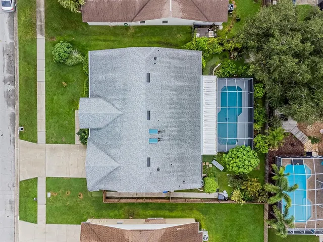 aerial view of a house with a yard and large tree