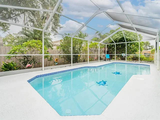 a view of a swimming pool with a yard and plants