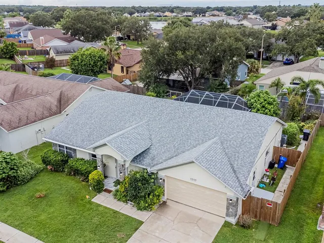 an aerial view of a house with a yard garage and lake view