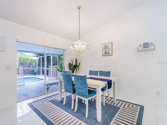 a dining room with furniture a chandelier and wooden floor