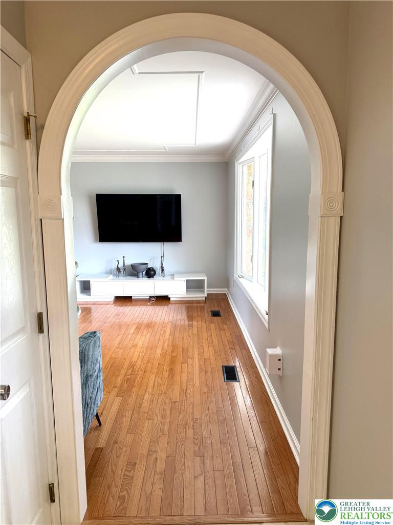 10 Dusty Road Easton, PA 18045 - Photo 20 of 35 An inviting arched doorway opens into a well-lit living area featuring rich hardwood flooring.