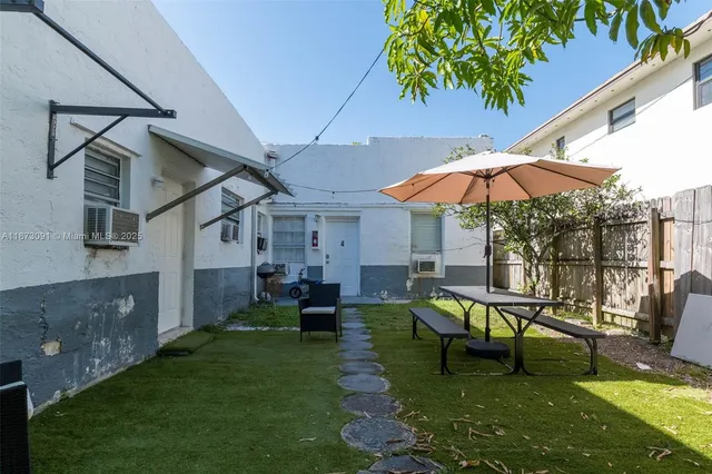 a view of a house with backyard porch and sitting area