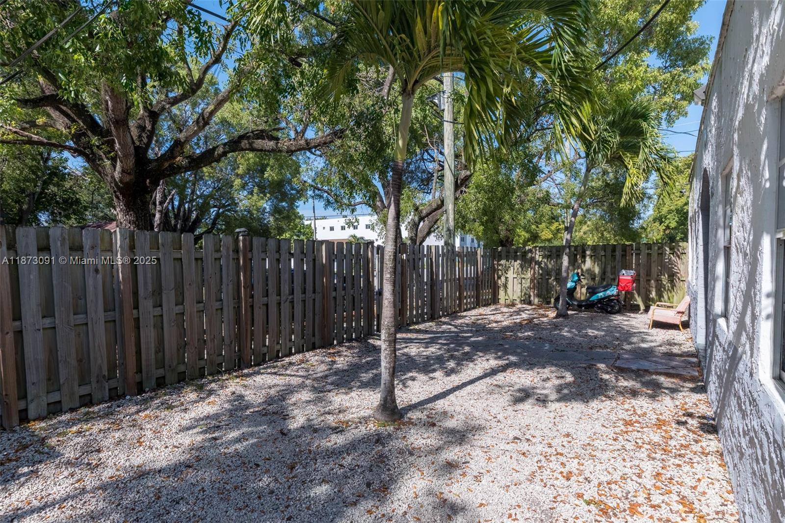 180 Northwest 59th Street Miami, FL 33127 - Photo 16 of 23 a view of a backyard with wooden fence and a large tree