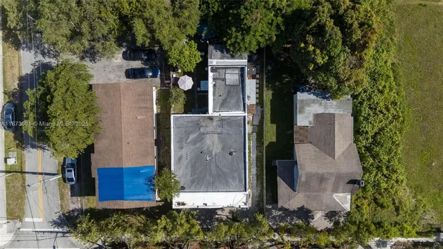 an aerial view of a house with a yard and large tree