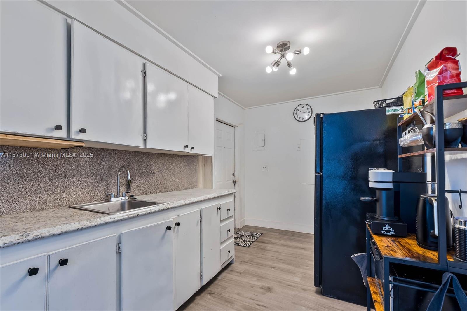 180 Northwest 59th Street Miami, FL 33127 - Photo 3 of 23 a kitchen with stainless steel appliances a sink cabinets and wooden floor