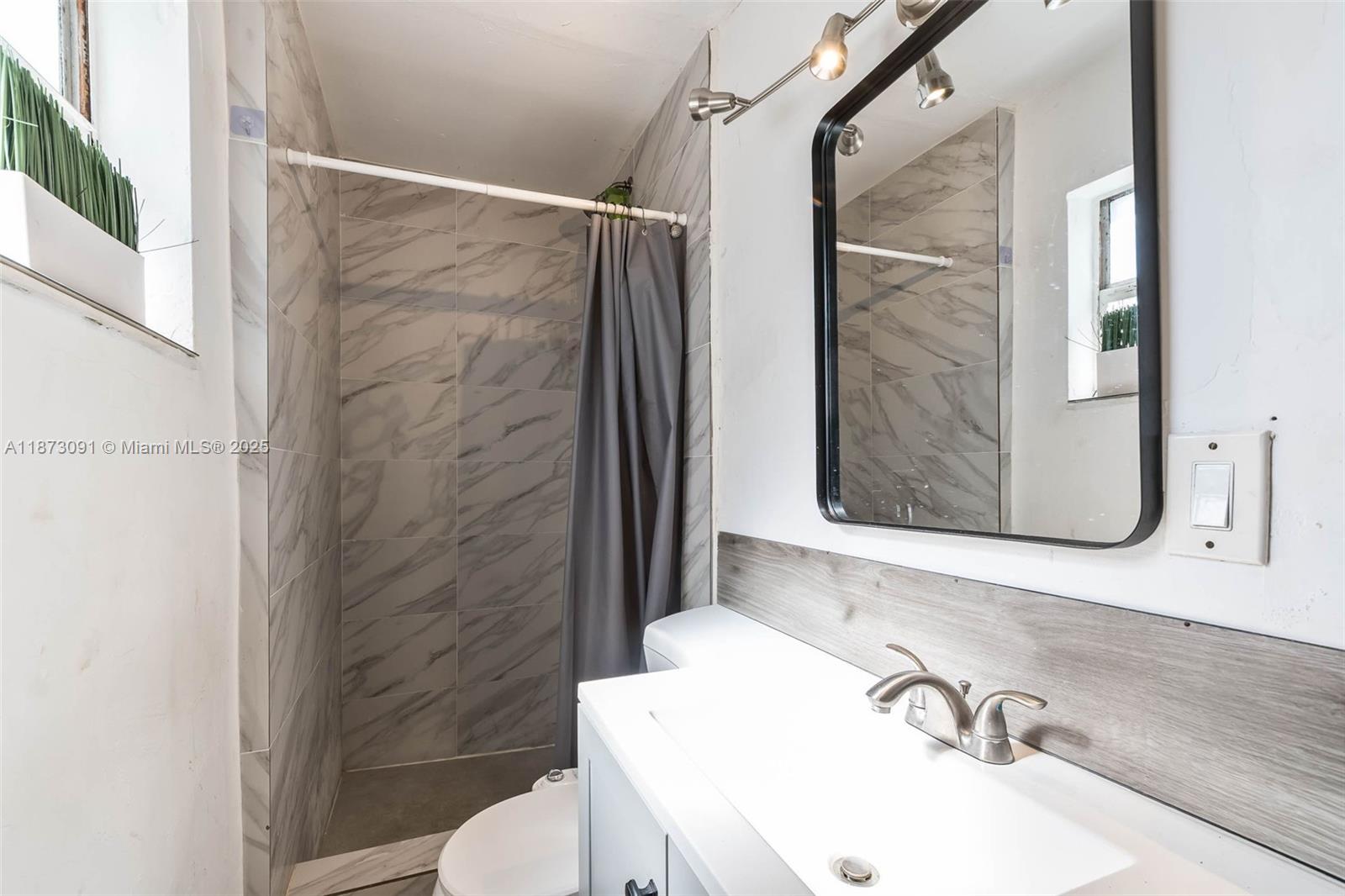 180 Northwest 59th Street Miami, FL 33127 - Photo 5 of 23 a bathroom with a sink and a mirror