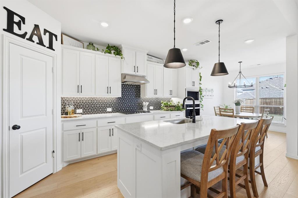 4420 Minnow Cove Oak Point, TX 75068 - Photo 13 of 40 a kitchen with stainless steel appliances kitchen island granite countertop a sink and cabinets