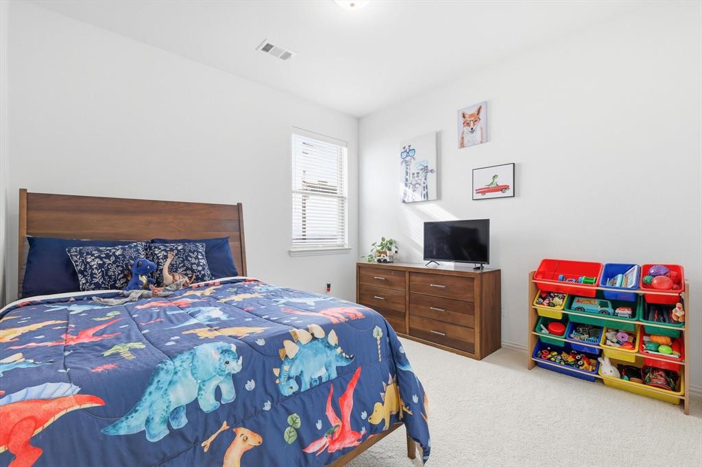 4420 Minnow Cove Oak Point, TX 75068 - Photo 29 of 40 a bedroom with a bed and a dresser in it