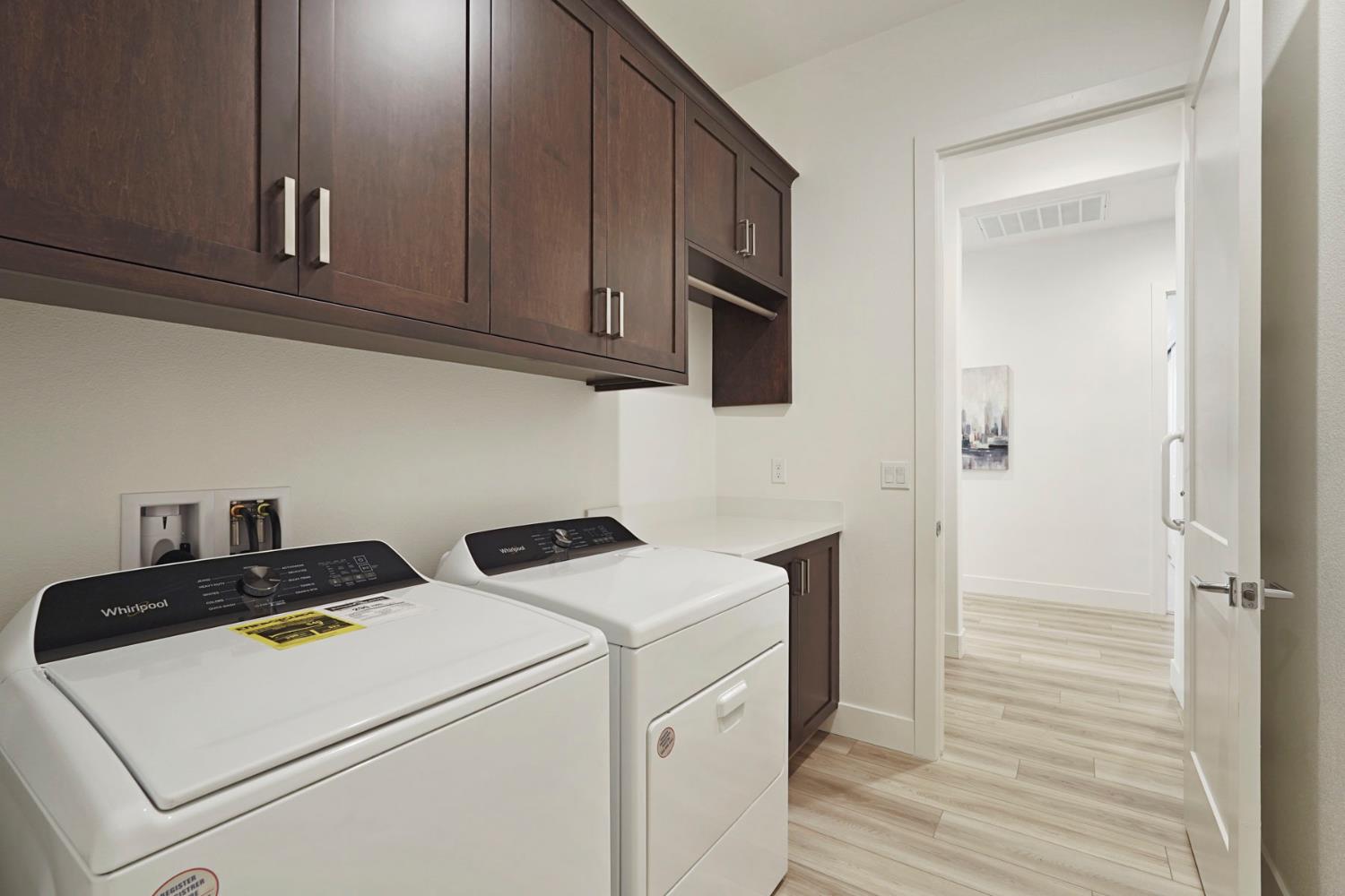 1839 Snowflower Place Tracy, CA 95377 - Photo 20 of 53 a view of washer and dryer with wooden cabinets