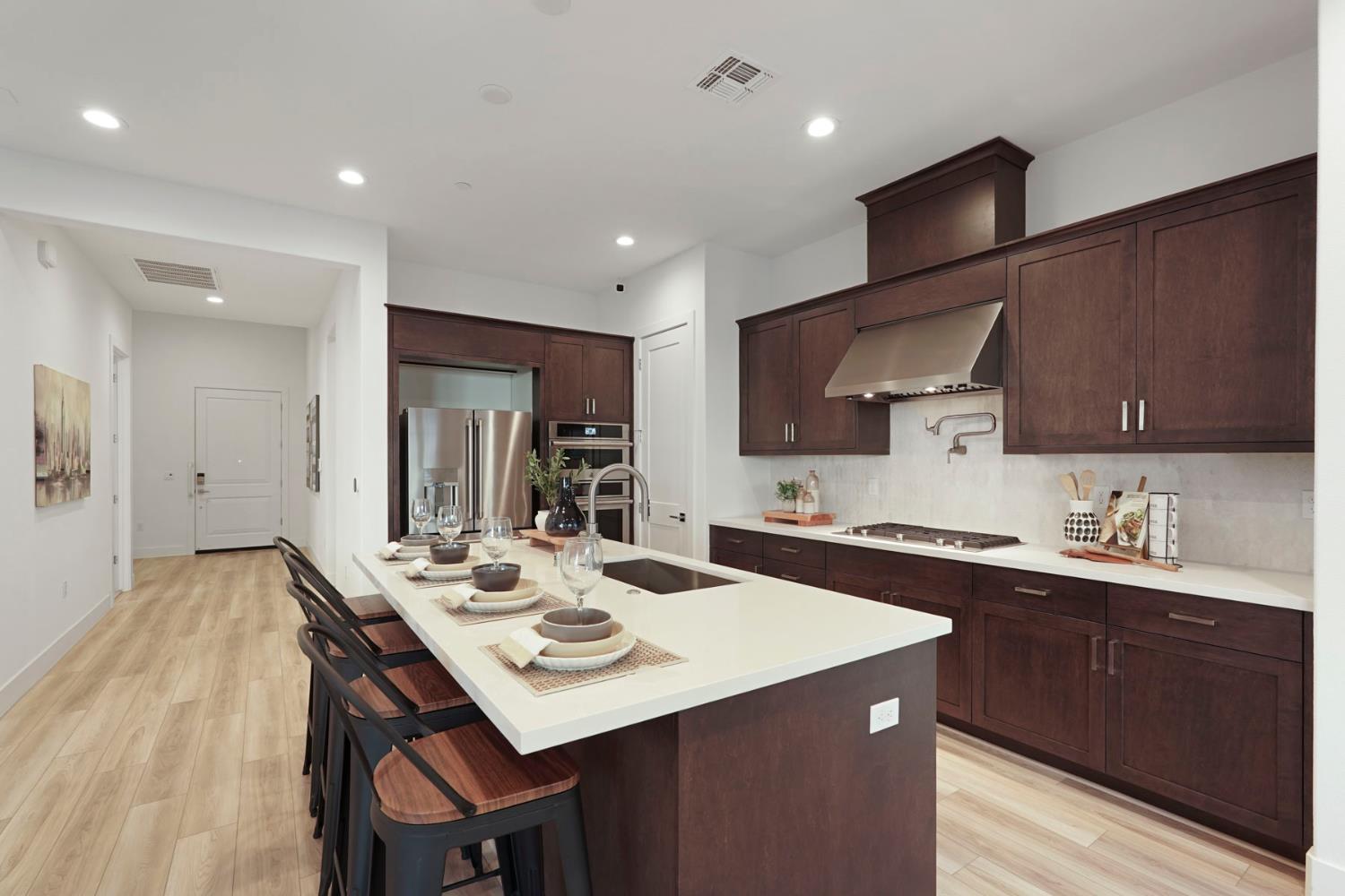1839 Snowflower Place Tracy, CA 95377 - Photo 9 of 53 a kitchen with a sink a kitchen island and stainless steel appliances