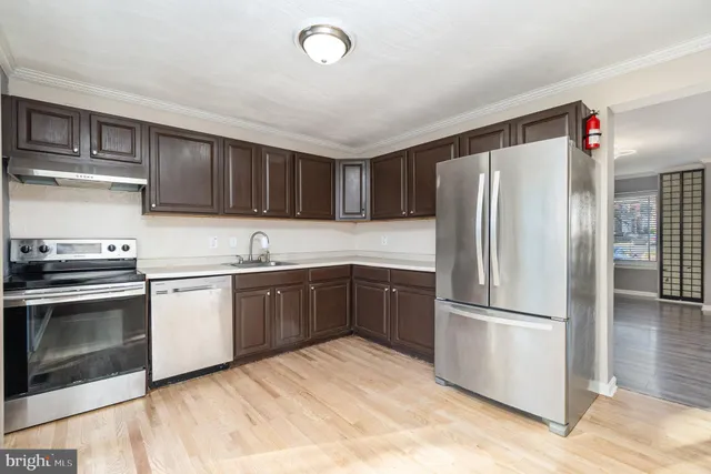 a kitchen with a refrigerator sink and wooden cabinets