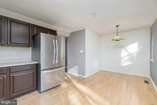 a bathroom with a refrigerator sink and cabinets
