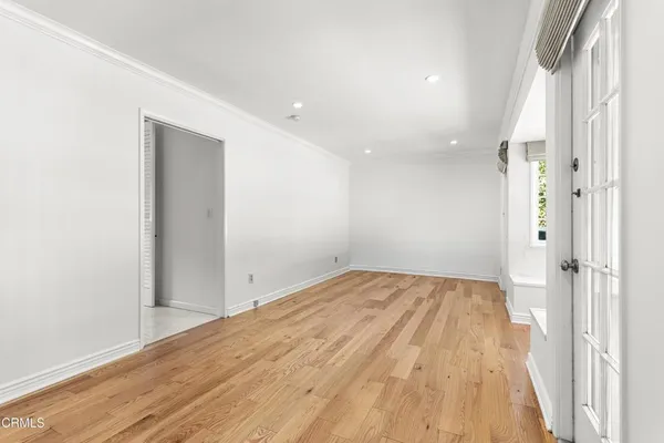 a view of a big room with wooden floor and windows