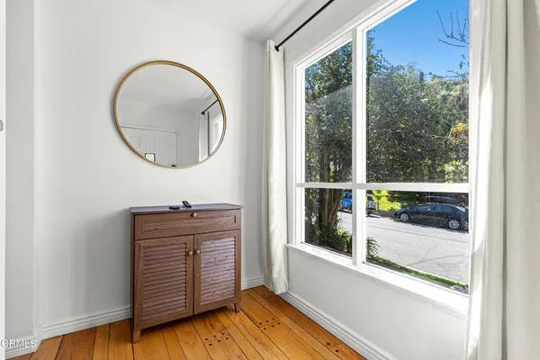 an entryway with wooden floor and windows