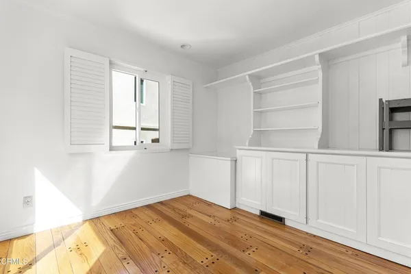 a view of empty room with wooden floor