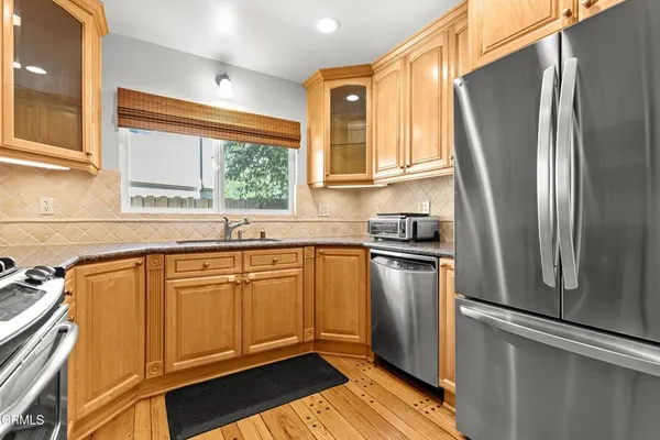 a kitchen with stainless steel appliances granite countertop a refrigerator and a sink