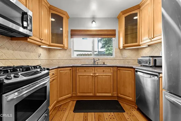 a kitchen with granite countertop stainless steel appliances a stove a sink and a microwave