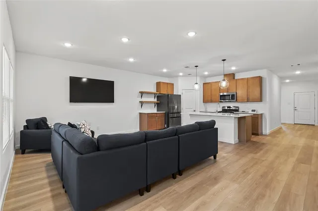 a kitchen with stainless steel appliances a stove a refrigerator a sink and a microwave