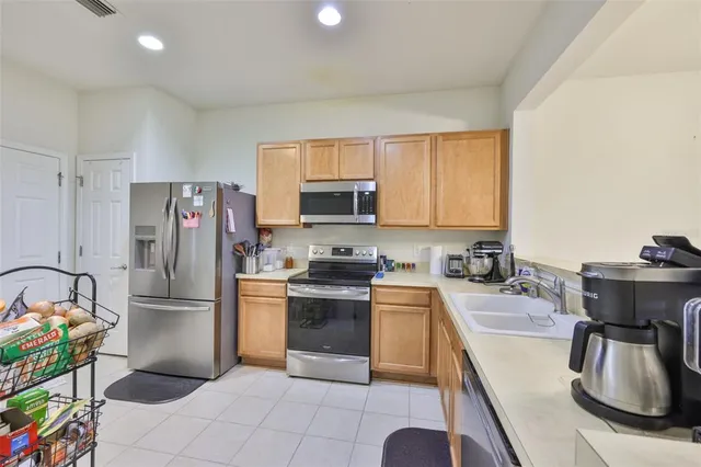 a kitchen with granite countertop a sink stove and refrigerator