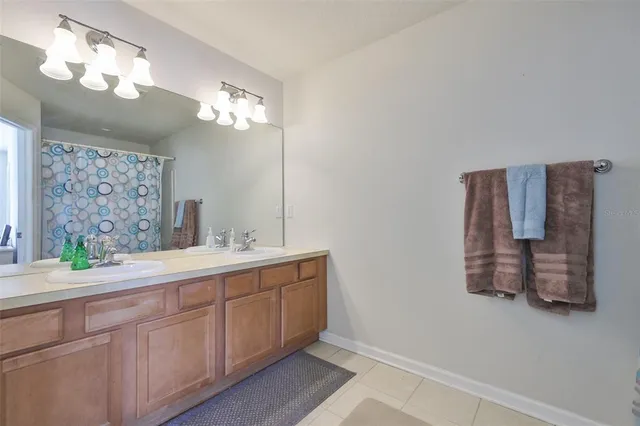 a spacious bathroom with a double vanity sink and a mirror