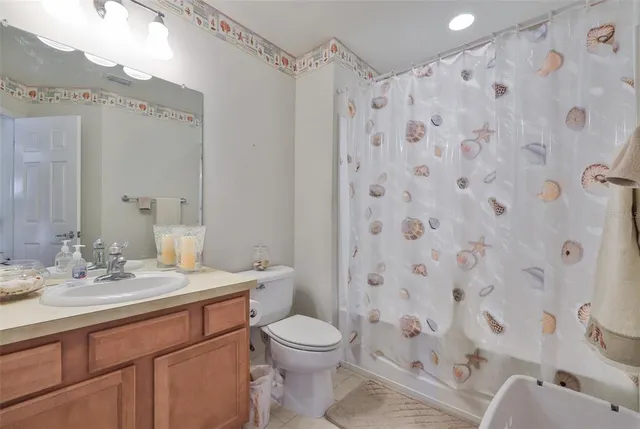 a bathroom with a sink a toilet and shower curtain