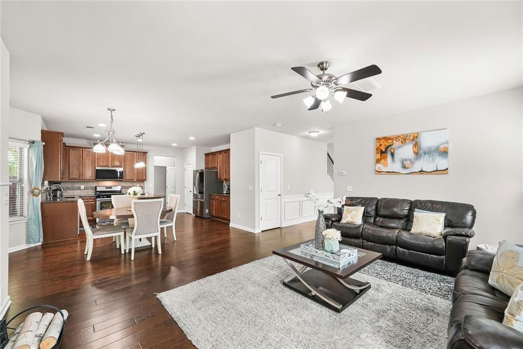 7823 Shertall Road Fairburn, GA 30213 - Photo 6 of 40 a living room with furniture kitchen view and a chandelier