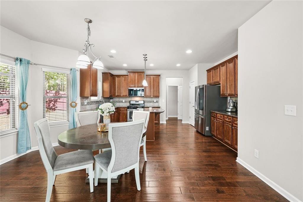 7823 Shertall Road Fairburn, GA 30213 - Photo 10 of 40 a view of a dining room and livingroom with furniture wooden floor a chandelier