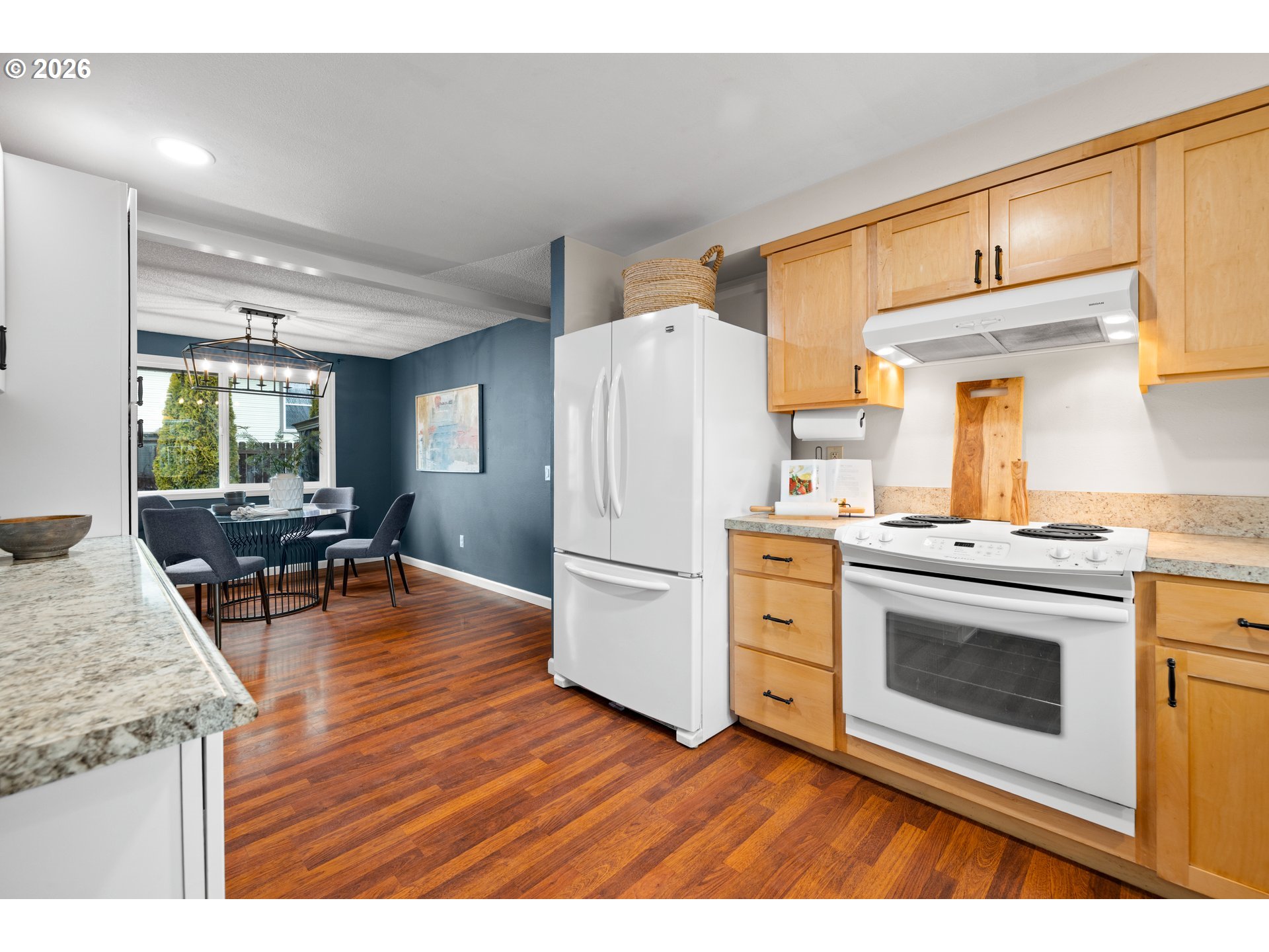 493 South Emerald Loop Cornelius, OR 97113 - Photo 3 of 46 a kitchen with a refrigerator a stove top oven a dining table and chairs