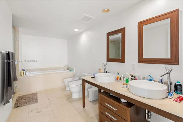 a bathroom with a granite countertop sink mirror and a toilet