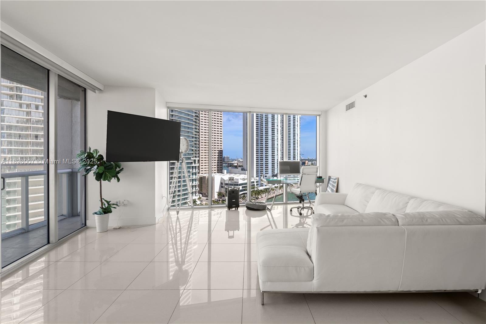 465 Brickell Avenue, Unit 1602 Miami, FL 33131 - Photo 4 of 30 a living room with furniture a flat screen tv and a large window
