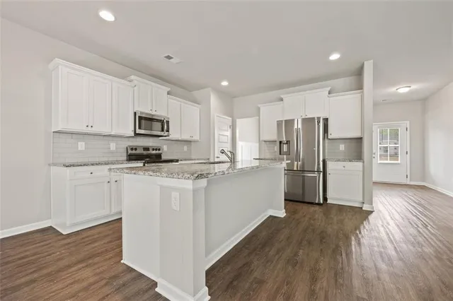 a kitchen with white cabinets and stainless steel appliances