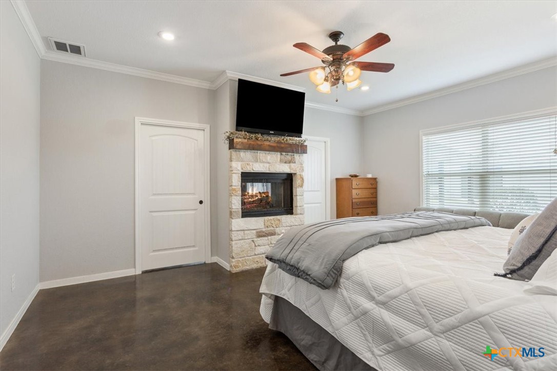 645 West Big Elm Road Troy, TX 76579 - Photo 14 of 37 a bedroom with a large bed and a ceiling fan