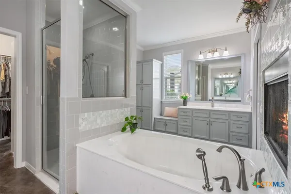 a bathroom with a tub sink and mirror