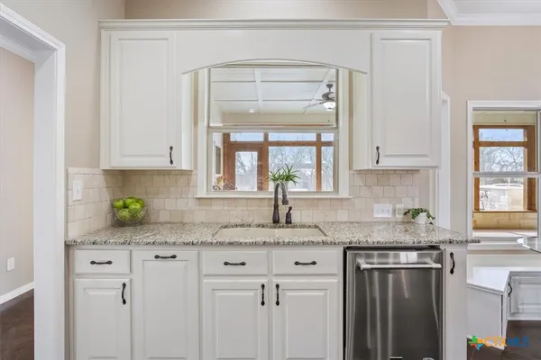 a kitchen with stainless steel appliances white cabinets and a granite counter tops