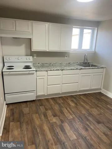 a kitchen with granite countertop a stove a sink and a granite counter tops